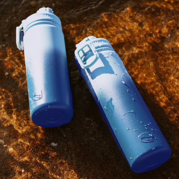 Two blue water bottles on a textured brown surface